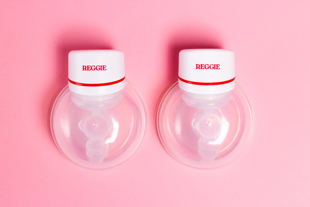 Two Reggie Baby wearable breast pumps with a pink background