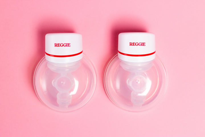 Two Reggie Baby wearable breast pumps with a pink background