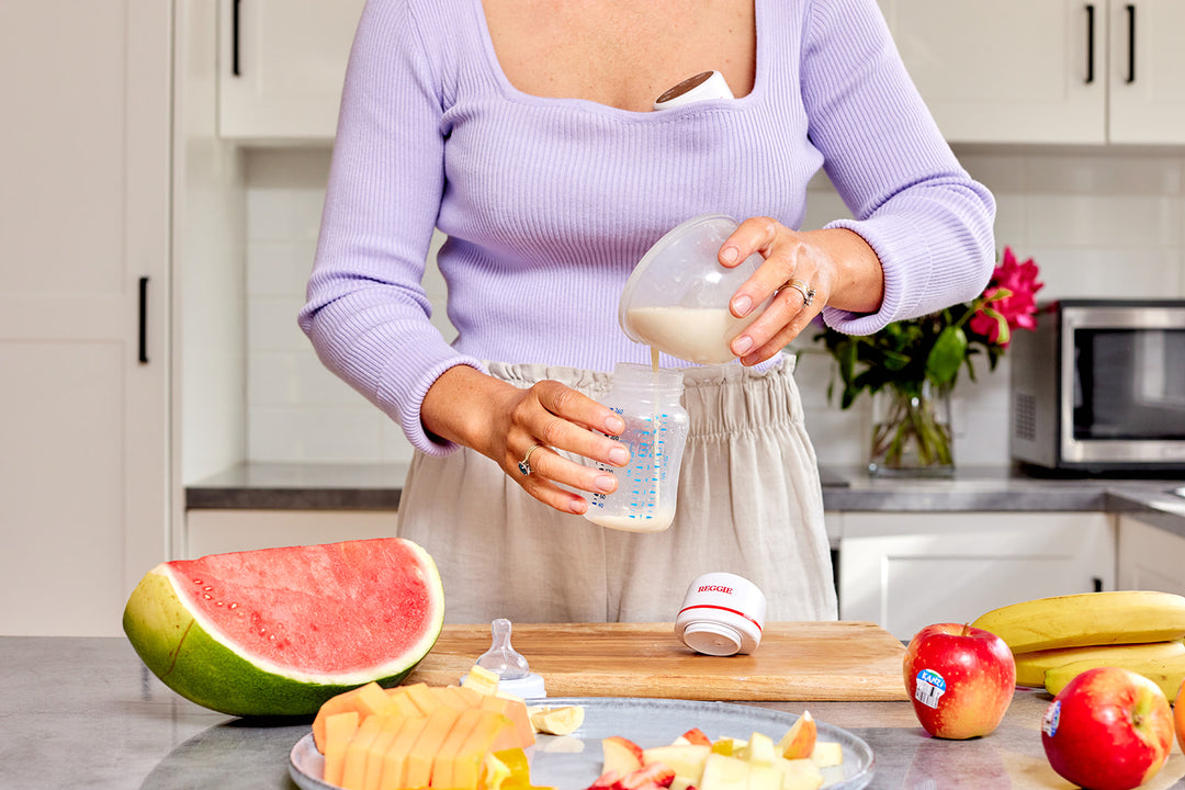Woman pouring breast milk from breast pump into baby bottle after use in the kitchen